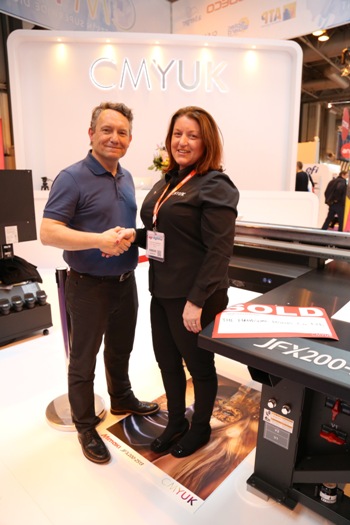 Rob Harrison of the Handsome Prints Company shakes hands on the deal with Sarah Fenna on the CMYUK stand at Sign & Digital UK